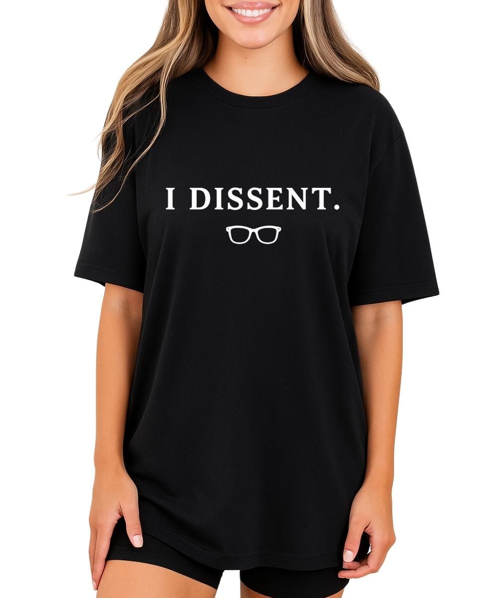 I Dissent Shirt – black oversized graphic tee with bold white I Dissent text and RBG signature glasses, worn by woman, feminist statement tee