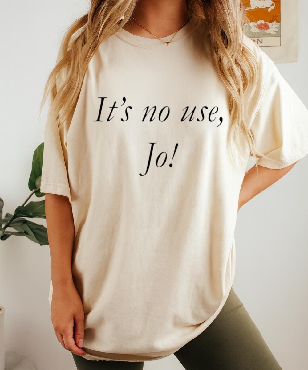 Cream t-shirt with “It’s no use, Jo!” quote in black script lettering
